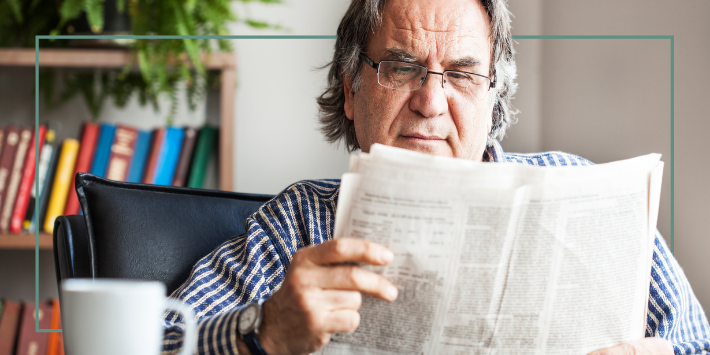 Retired man reading newspaper